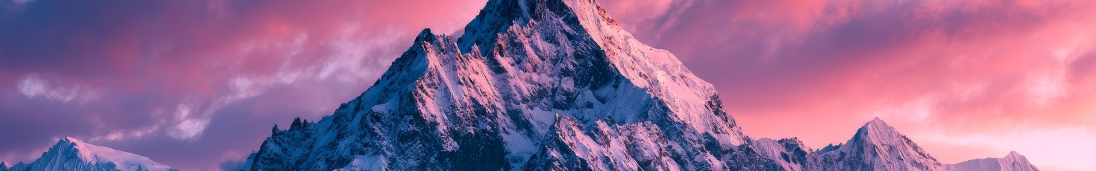 Jagged snow-capped mountain peak under pink sunrise clouds